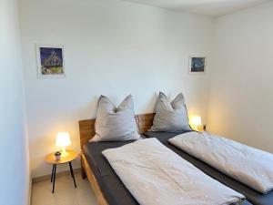 two beds in a room with two lamps at D2 Luxus-Penthouse mit Dachterrasse - Bis 9 Personen - A81 - Stuttgart - Messe - Daimler - ab 5 Nächte - Business Center und Konferenzraum separat buchbar in Schönaich
