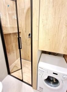 a washer and dryer in a kitchen with a glass door at Hanza Tower 615 in Szczecin