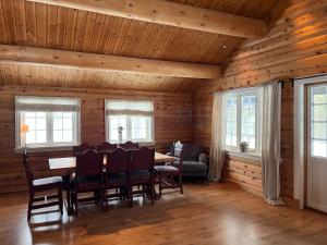 a dining room with a table and chairs and windows at Large and beautiful cabin in Løfald