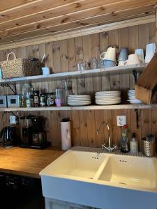a kitchen with a sink and a shelf with dishes at Large and beautiful cabin in Løfald +55 photos