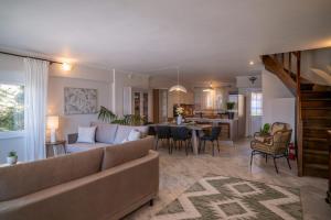 a living room with a couch and a dining room at Etesians Seaside House in Ágios Konstantínos