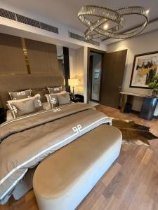 a bedroom with a large bed with a chandelier at Oyster court gulberg in Lahore