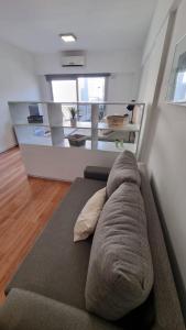 a large couch in a living room with a room withwindows at Muy Hermoso Departamento en Recoleta in Buenos Aires