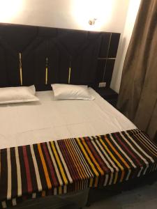 Postel nebo postele na pokoji v ubytování Hotel Guru ji residency