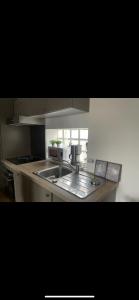 a kitchen with a sink and a stove at Appartement bord de mer in Jullouville-les-Pins +6 photos