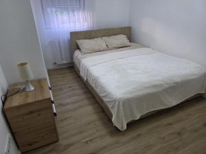 a bed in a bedroom with a wooden floor at Varosmala in Novi Pazar