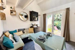 een woonkamer met een bank en een tafel bij Maisonnette de charme Bord de mer Piscine in Guidel +21 foto's