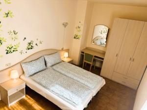 a small bedroom with a bed and a mirror at Appartamenti Belvedere in Malcesine