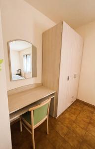a desk with a mirror and a chair in a room at Appartamenti Belvedere in Malcesine