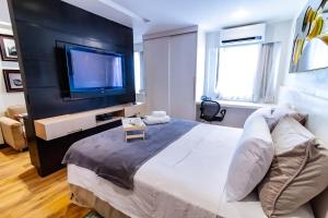 a bedroom with a large bed and a flat screen tv at Ozped Private Flats Comfort Suites in Brasília +13 photos