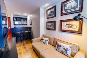 a living room with a couch and pictures on the wall at Ozped Private Flats Comfort Suites in Brasília