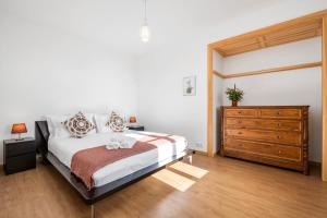 a bedroom with a bed and a wooden dresser at Casa os Gauleses in Gaula