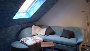 a living room with a blue couch and a window at Ferienwohnung Natur pur in Oberschönau