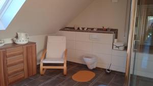 a bathroom with a toilet and a chair in it at Ferienwohnung Natur pur in Oberschönau