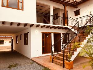 una casa con una escalera que conduce a la puerta principal en HOTEL RUTA 40 VILLA DE LEYVA, en Villa de Leyva