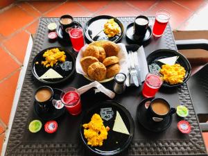 Una mesa cubierta con platos de comida y bebidas. en HOTEL RUTA 40 VILLA DE LEYVA, en Villa de Leyva