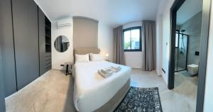 a bedroom with a large white bed and a bathroom at Lux Level 4 Penthouse Tower 206 in Nicosia