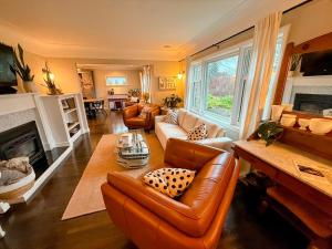 a living room with leather furniture and a fireplace at Couple's Oasis at Horner Park in Victoria