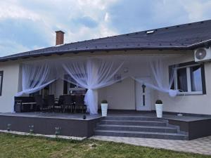 a house with white curtains on the back porch at Reginahouse in Szigetszentmiklós