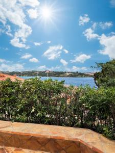 a view of a body of water with trees at Apartment La Capitaneria in Porto Cervo