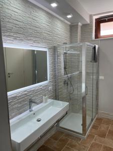 a bathroom with a white sink and a shower at Le Finestre sul Duomo in LʼAquila +17 photos