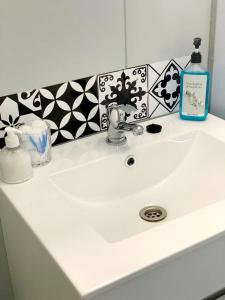 PostmasburgにあるLa Maison Guesthouseのバスルーム(シンク、石鹸1本、石鹸ディスペンサー付)