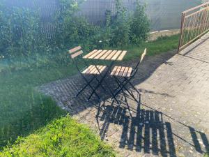 une table de pique-nique et une chaise assise à côté d'une clôture dans l'établissement Le lodge, à Dole