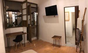 a room with a desk and a television and a mirror at Villa Mediterranea in Campeche