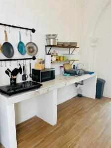 a kitchen with a white counter with pots and pans at Villa Mediterranea in Campeche