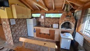 a kitchen with a stove and a stone oven at Лорета-Камен бряг in Kamen Bryag