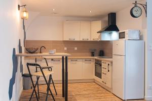 a kitchen with a refrigerator and a table and chairs at Seven Keys - Enclave du Coiron in Saint-Vincent-de-Barrès