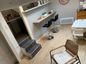 a living room with stairs and a chair and a table at Joli logement très accueillant in Nantes