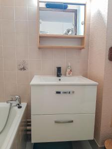 un bagno con un lavandino, uno specchio e una vasca di Y'Hôtes - Studio à 5min à pieds des pistes de ski a Habère-Poche Altre 9 foto
