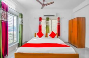 a bedroom with a large bed with red and white sheets at Hotel O Amar Raj Stay in Kolkata