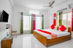 a bedroom with a bed with red and green curtains at Hotel O Amar Raj Stay in Kolkata