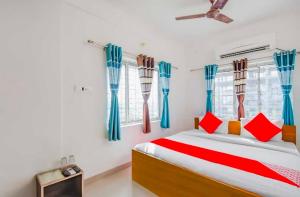a bedroom with a bed with red and blue curtains at Hotel O Amar Raj Stay in Kolkata
