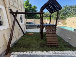 a wooden structure sitting in the grass next to a pool at Durban Holiday Apartments by Mieli Estates , Unit 6 in Durban