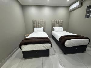 two beds sitting next to each other in a room at Durban Holiday Apartments by Mieli Estates , Unit 6 in Durban +25 photos