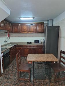 eine Küche mit Tisch und Kühlschrank in der Unterkunft Refugio Catanho in São Vicente