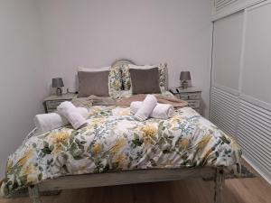 ein Schlafzimmer mit einem Bett mit geblümter Bettdecke in der Unterkunft Refugio Catanho in São Vicente