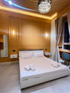a bedroom with a large white bed with a chandelier at Mia House Prestige in Rome