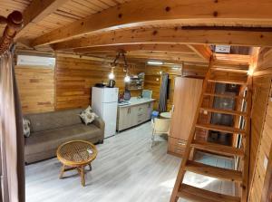a living room with a couch and a kitchen at Turkuaz Bungalows in Cıralı