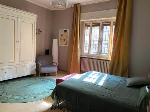 a bedroom with a bed and a chair and a window at A casa di Mario in Riola