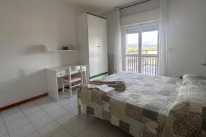 a bedroom with a bed and a desk and a window at Residenza Pierre & Vacances Luni Mare in Luni