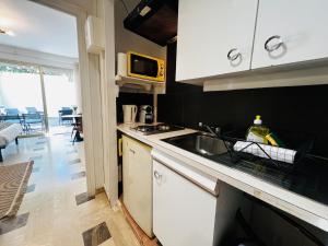 a kitchen with a sink and a microwave at Villa Estérel Large Studio with Terrace in Cannes