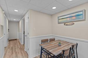 a dining room with a wooden table and chairs at Paradise Towers #104 in Carolina Beach