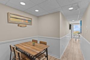 a dining room with a wooden table and chairs at Paradise Towers #104 in Carolina Beach +33 photos