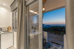 szklanymi drzwiami prowadzącymi na balkon z widokiem w obiekcie Naxian View w mieście Naksos