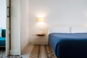 a bedroom with a bed and a lamp on a wall at Hotel Casa Bonay & Spa in Barcelona