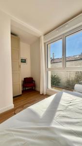 a bedroom with a bed and a large window at Maison 88 Malakoff in Malakoff